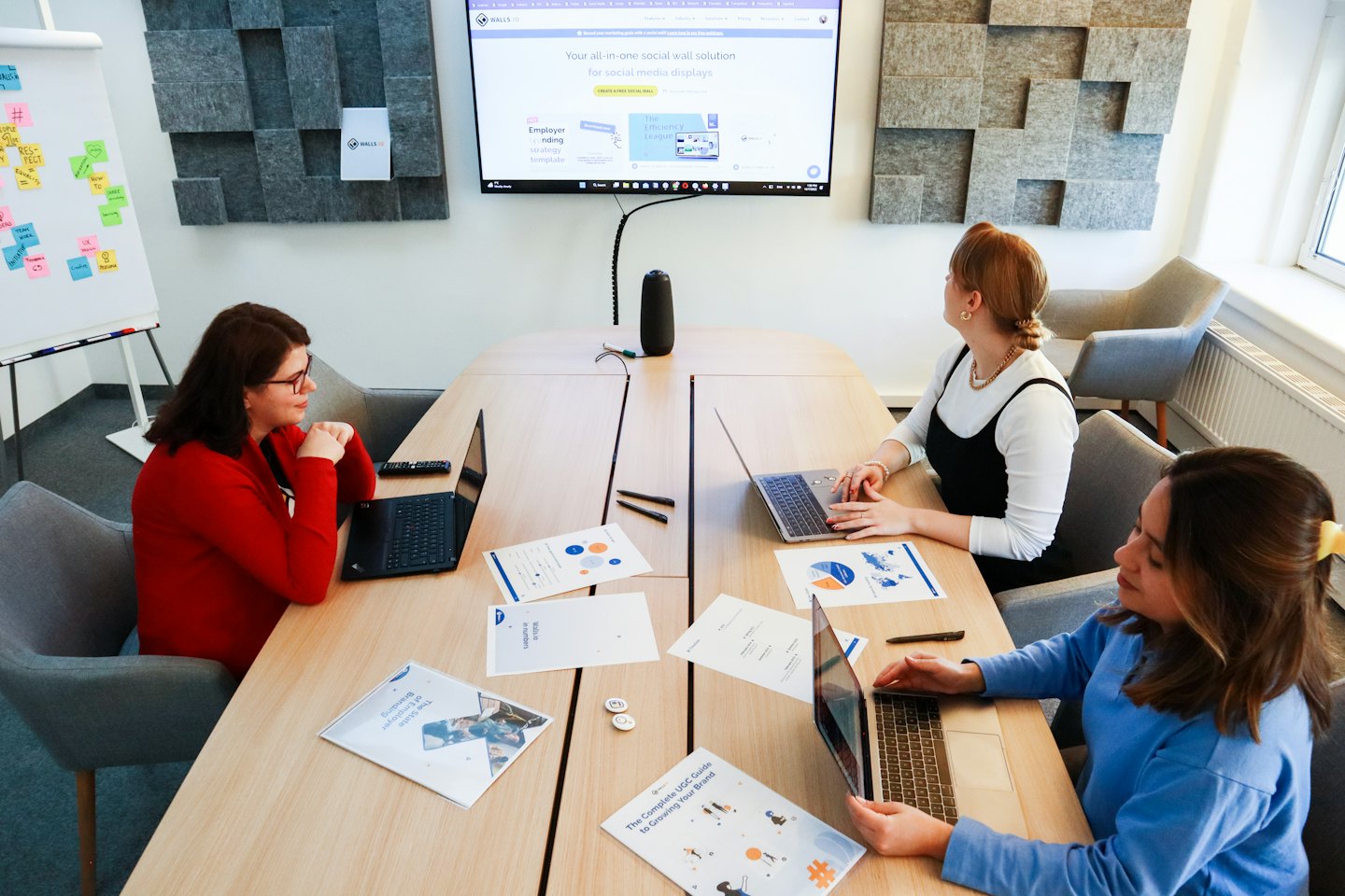 Trois femmes travaillent ensemble sur des ordinateurs portables à une table de bureau.