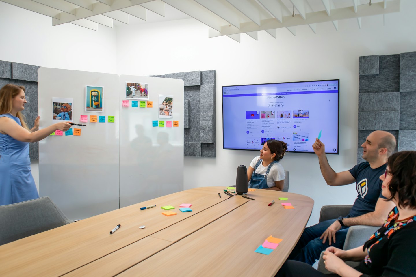 Des collègues échangent des idées avec des post-it sur un tableau blanc.