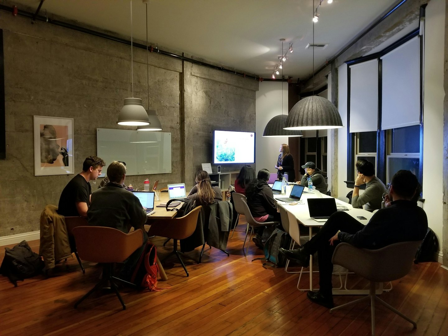 Des professionnels collaborent autour de tables dans une salle de réunion moderne.